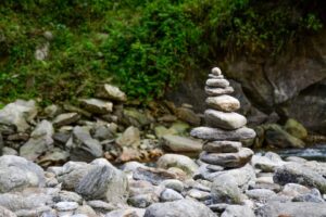 Global Pranksters Set up Statues and Rocks neatly stacked along a river