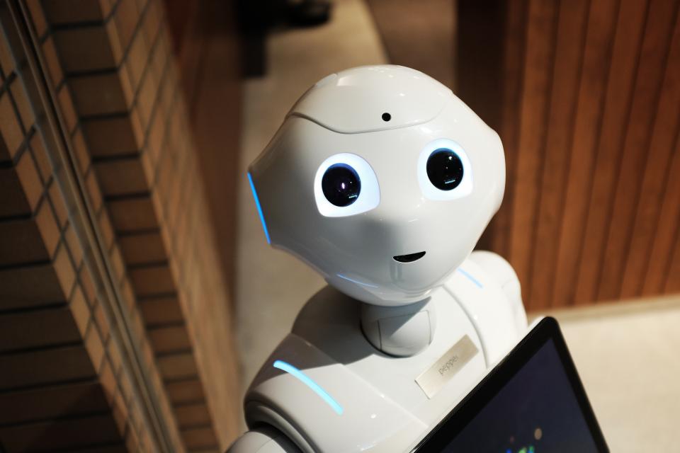 Humanoid robot looking up at camera to smile after Elon Musk says “Global Warming” will take us all out to dinner